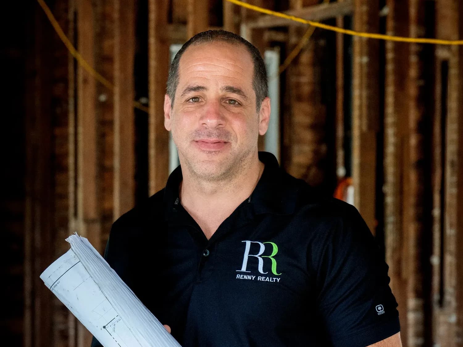 Gus Renny standing inside a gutted historic home mid-renovation